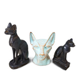 A set of three Egyptian-themed cat statues, with one larger black statue, one smaller black statue, and one patina-colored bust.