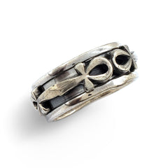 A silver spinner ring with Egyptian ankh symbols on it, set against a white background.
