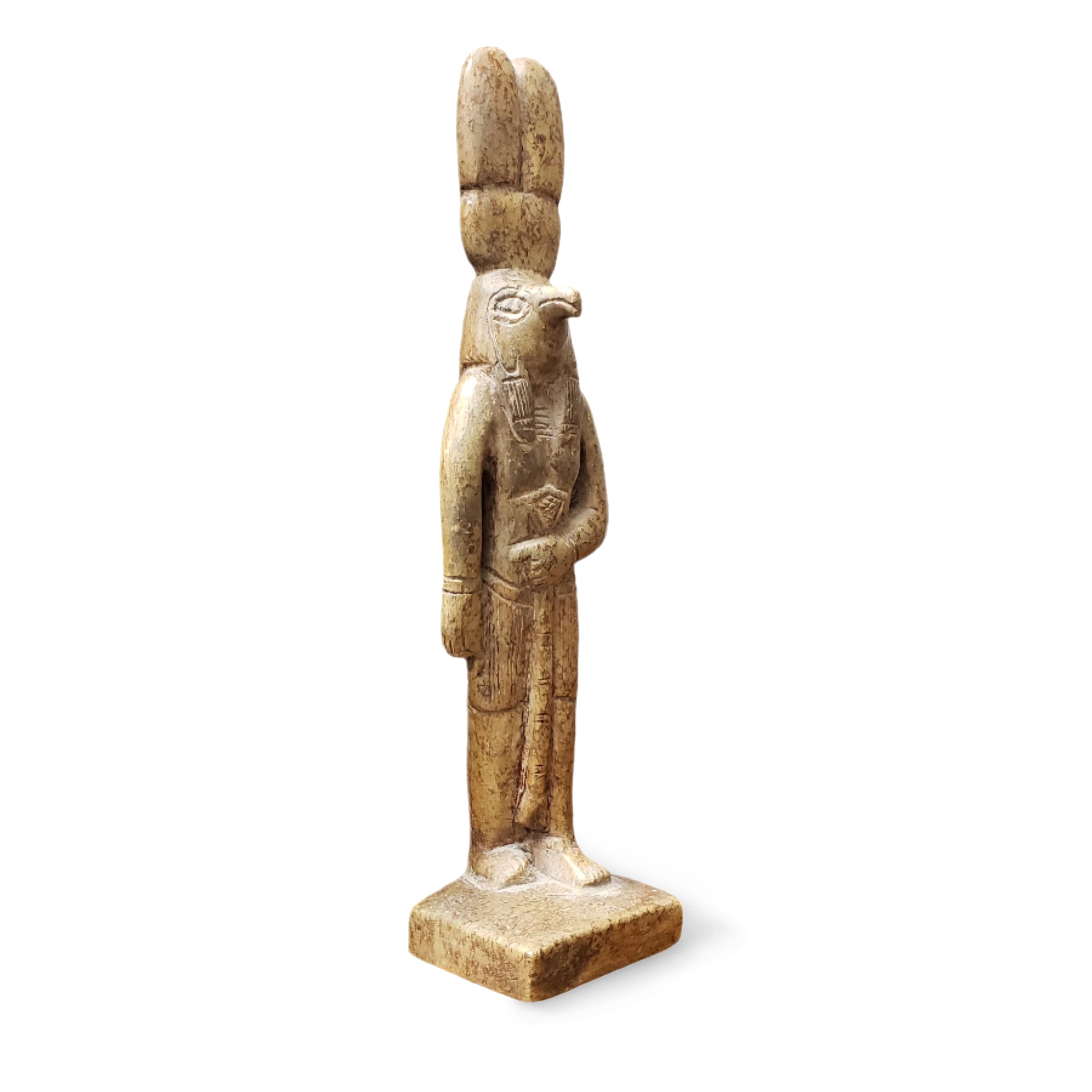 A statue of the Egyptian god Montu, depicted as a human figure with the head of a falcon, made of sandstone with a hieroglyphic design in the background.