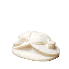 Decorative white shell on a wooden surface next to a book