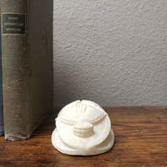Decorative white object on a book with a wooden surface and gray wall background