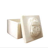 Decorative stone block with carvings on a wooden surface