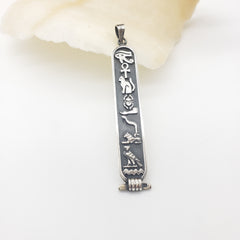 Silver cartouche with intricate designs on a white background
