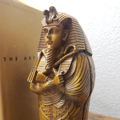 Decorative book with a gold cover featuring an Egyptian-style sphinx design.