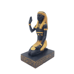 Statue of a kneeling figure with black and gold coloring on a white background