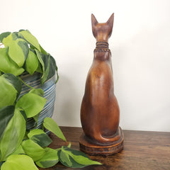 Cat-shaped object on a white background with green leaves in the foreground