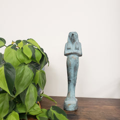 Decorative Egyptian god Horus statue with a plant in the foreground