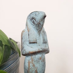Egyptian god Horus statue with a distressed finish on a white background