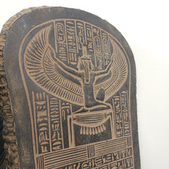 Wooden block with ancient Egyptian hieroglyphics and a falcon design on a white background