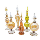 Collection of colorful glass bottles with decorative elements on a white background