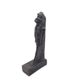Black stone statue of a cat on a pedestal with intricate carvings against a white background