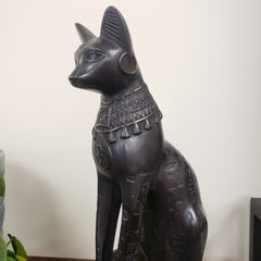 Black decorative figure of a cat with hieroglyphic design on a white background