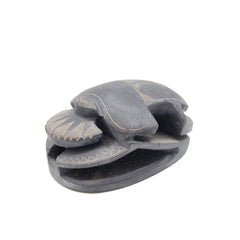 Decorative stone sculpture of a scarab on a white background