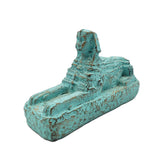 Turquoise-colored Sphinx figurine on a white background