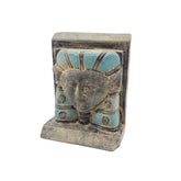 Decorative sculpture of a face with blue headdress on a white background