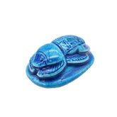 Blue ceramic scarab beetle on a white background