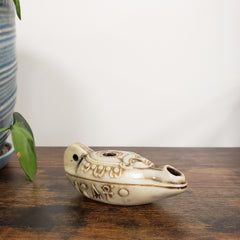 Decorative ceramic Egyptian goddess Hathor Oil Lamp with intricate designs on a wooden surface.
