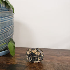 Decorative gold scarab statue with an embossed design on a white wall.