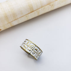 Gold ring with engraved symbols on a white surface