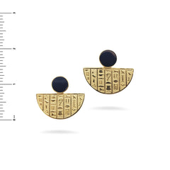Pair of gold earrings with black stones and hieroglyphic designs on a white background.