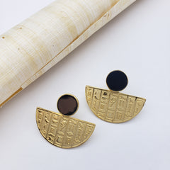 Gold earrings with hieroglyphic designs on a white background