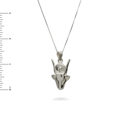 Silver pendant necklace on a white background with a ruler for scale.