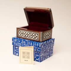 Wooden jewelry box with geometric patterns on a beige background