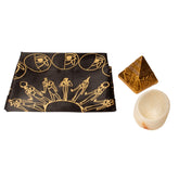 Decorative cloth with Egyptian-themed design, pyramid-shaped object, and stone on a white background