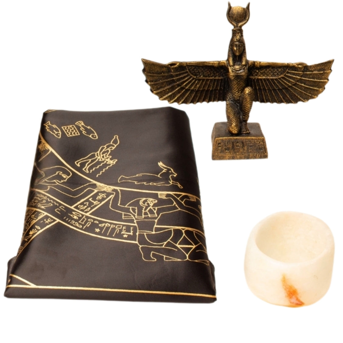 Bronze statue of a winged figure, black cloth with gold designs, and a candle on a white background