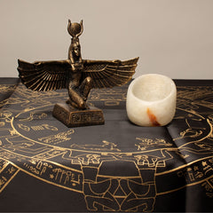 Bronze statue of Isis on a black cloth with gold designs