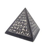 Pyramid-shaped object with hieroglyphic designs on a white background