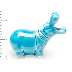 Blue ceramic hippo figurine on a white background with a ruler for scale.