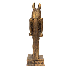 A small gold-toned figurine of a horned deity, shown from the back on a plain white background.