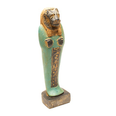 Decorative Egyptian-style figure with green body and gold head on a white background