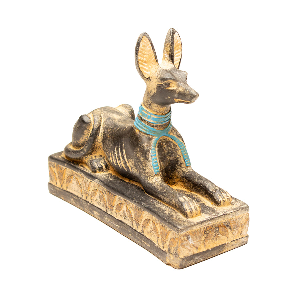 Statue of a dog-like creature with a blue collar on a white background