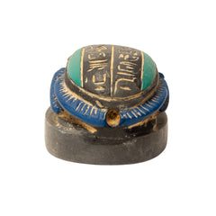 Decorative object with blue and green top and black base on a white background