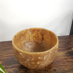 Brown stone bowl on a wooden surface with a white background