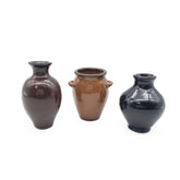 Three ceramic vases in brown and black on a white background