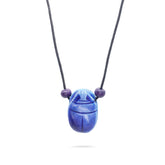 Blue scarab necklace with purple beads on a white background