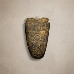 Bronze artifact with intricate carvings on a white background
