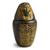 Egyptian canopic jar with a removable lid, featuring a human-headed Imsety statue and hieroglyphic details on a black background.