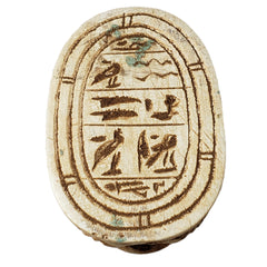 Ancient Egyptian scarab with hieroglyphics on a white background