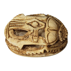 Carved stone scarab with intricate patterns on a white background