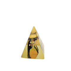 Pyramid-shaped object with a design of a person wearing a headdress on a white background