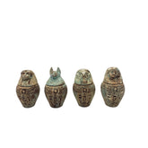 Four Egyptian-style canopic jars with animal heads on a white background