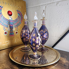 Decorative glass bottles with gold accents on a wooden surface