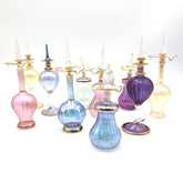 Collection of colorful glass bottles with gold accents on a white background