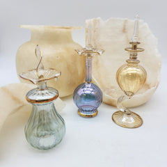 Set of glass bottles with decorative elements on a light background