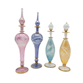 Set of four colorful glass perfume bottles with gold bases on a white background
