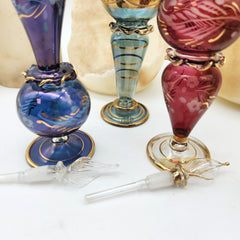 Colorful glass perfume bottles on a white background